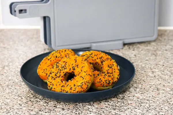 Cadılar Bayramı temalı donutlar, portakal kremalı, siyah yeşil ve beyaz serpiştirilmiş mutfak tabağı.