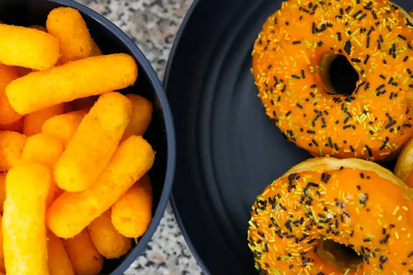 Cadılar Bayramı temalı peynirli puf ve donut tabağı mutfağın üstünde.
