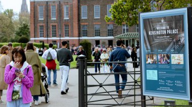 Londra, İngiltere, 10 Mayıs 2023: Kensington Sarayı 'nın yanındaki telefonuna bakan turist.