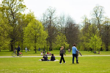 Londra, İngiltere, 30 Nisan 2023: Kensington Bahçeleri çimenlerde yürüyen insanlarla dolu