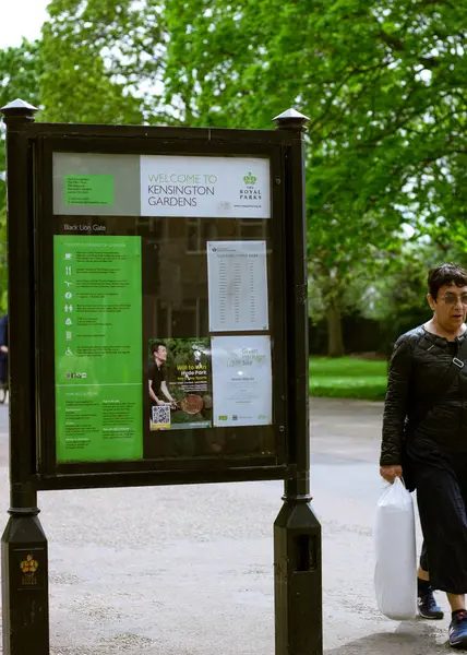 stock image London, England, April 30 2023: Kensington Gardens board with information and a lady passing by