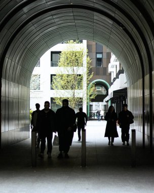 Oxford Caddesine yakın Londra 'da bir oyun salonunun altında yürüyen siluetler.