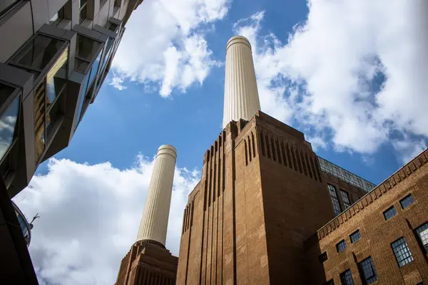Battersea Elektrik Santrali manzarası aşağıdan mavi gökyüzü ve yanında Frank Gehry binası var.