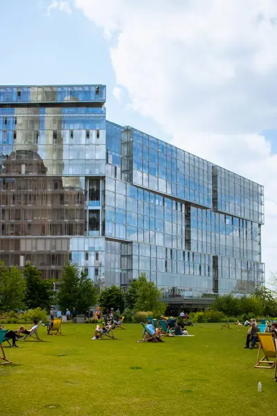 Battersea Elektrik Santrali 'nin arka planında güneşli bir günün tadını çıkaran insanlar.