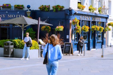 Dışarıdan geleneksel bir bar ve Cutty Sark 'ta yürüyen insanlar var.