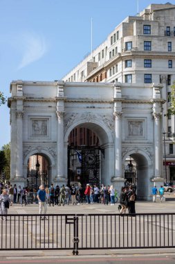 Full view of the Marble Arch in London with people walking around clipart