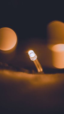 Yumuşak, sıcak bir bokeh etkisi ile çevrili, parıldayan bir LED ışığın yakın çekimi, samimi ve samimi bir ortam yaratır. Bayram ve festival temalı görseller için mükemmel..