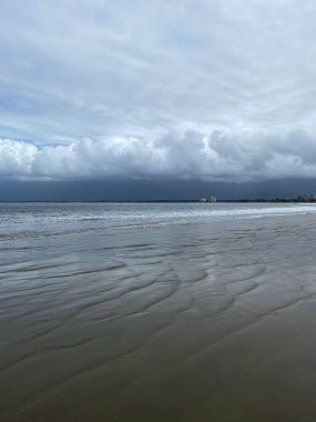 Kumsal, deniz, dalgalar, gökyüzü ve yağmur bulutları