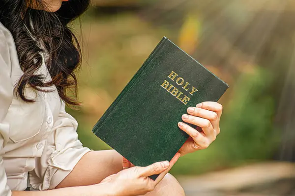 İncil 'deki bir kadının elleri. İncil 'in üzerinde Hıristiyanlık kavramları okuyup dua ediyor..