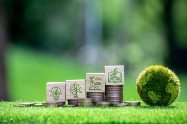 Karbon kredi ve CO2 emisyon azaltma kavramı. Gümüş para yığınında karbondioksit simgesi olan tahta küpler ve dünya haritalı yeşil küre. Küresel ısınma sürecini durdurmak için şirketlere vergi kredisi.
