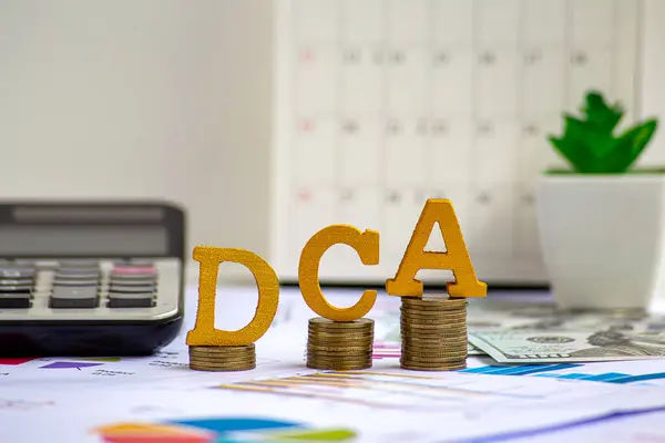 Paraların büyümesi üzerine tahtadan bloklar üzerine DCA metni. Dolar maliyet ortalaması yatırım stratejisi için arka plan, aylık, üç aylık hisse senedi tasarrufu. Fon alımları, İş ve Yatırım konsepti.