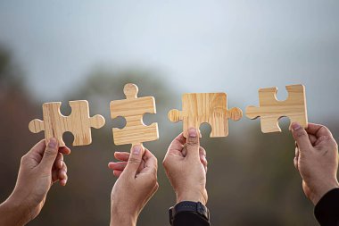 İş başarısı ve strateji çözümleri kavramı, Eller kadın güneş ışığı arka planına sahip çift bulmaca parçalarını birbirine bağlar