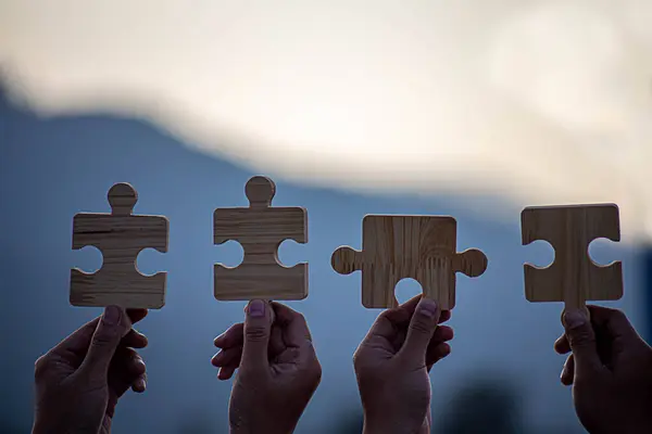 İş başarısı ve strateji çözümleri kavramı, Eller kadın güneş ışığı arka planına sahip çift bulmaca parçalarını birbirine bağlar