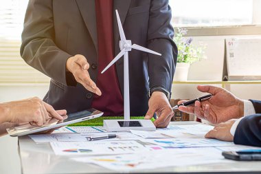 Çevre dostu ve yenilenebilir temiz enerji ürünlerinin pazarlanmasını tartışmak üzere strateji planlayan bir grup işadamı ile Eko şirketleri toplantısı. Yeşil işletme konsepti. Önde.