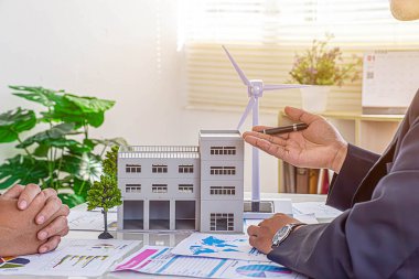 Uzmanlardan oluşan mimar ekibi inşaat sahasında dizüstü bilgisayar, inşaat projesi, işadamı ve plan tartışan işçi ve iş adamı kullanıyor.