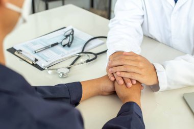 Doctor healthcare. Professional medical doctor in white uniform gown coat interview consulting patient reassuring his male patient helping hand