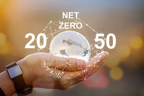 net sıfır ve karbon nötr konsept. İnsan eliyle kristal kürede sıfır metin. Sıfır net sera gazı emisyonları yeşil zemin üzerinde uzun vadeli, iklim-nötr stratejiyi hedeflemektedir.