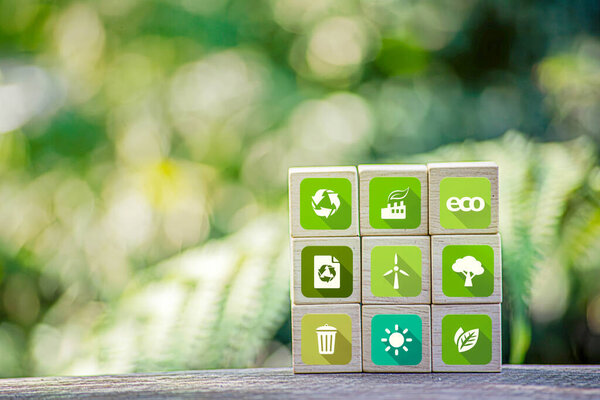Save of earth, saving environment, net zero emissions concept. Green business and sustainable development. World earth day. Hand puts wooden cubes with clean energy icon standing on eco friendly
