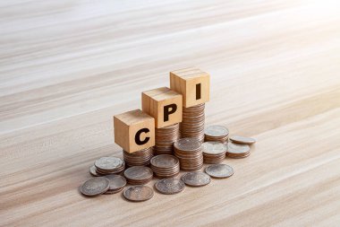 CPI, tüketici fiyat endeksi sembolü. Ahşap bloklar, CPI harfleriyle, tüketici fiyat endeksi, dolar banknotları, hesap makinesi ve bozuk paralarla. İş ve CPI, İş ve tüketici fiyat endeksi kavramı.