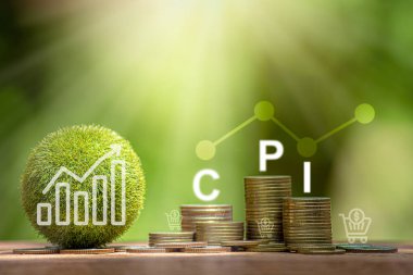 İşlemci, Tüketici Fiyat Endeksi Konsepti tahta bloklar ve bozuk para yığınında CPI yazıyor. Doğal yeşil zemin üzerinde küçük bir alışveriş arabası, emtia fiyatı enflasyonu ve yükselen enflasyon.