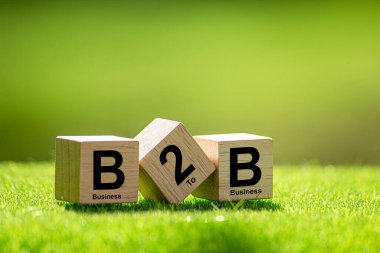 B2B 'de. İş 'ten iş alışverişine. İşten işe. Tahta bir bloğa çizilmiş B2B harfleri.