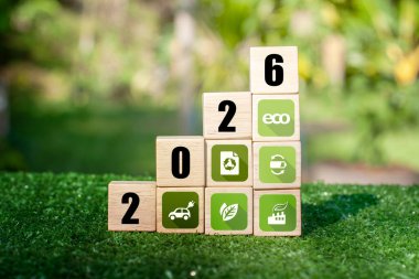 2026 yenilenebilir enerji ikonu ile ahşap blokta yeşil toprak. Sürdürülebilir şirket gelişimi, yeşil enerji sektörü, ESG, CO2, SDG ve Net Zero. Dünya Çevre Günü. Çevre dostu.