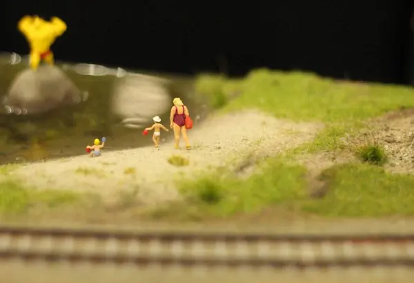 Anne ve çocuklar göl sahilinde.