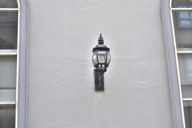 Evin arka planında siyah duvar olan eski bir lamba.