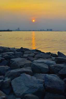Öğleden sonra gün batımında kumsal ve okyanus manzarası