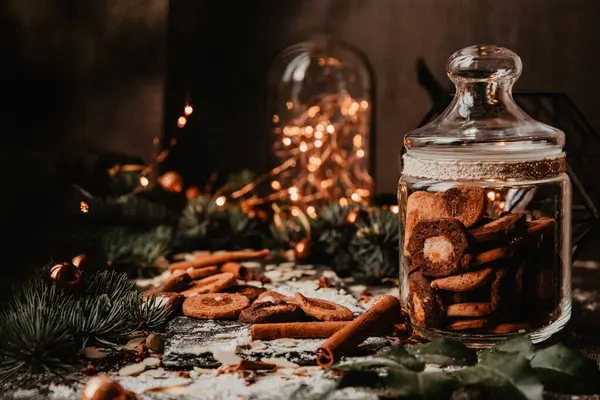 Tarçın çubukları ve festival ışıklarıyla çevrili bir kavanoz ev yapımı kurabiyenin yer aldığı kırsal bir tatil. Çam dalları, kış mevsimi için mükemmel sıcak bir atmosfer ekler..