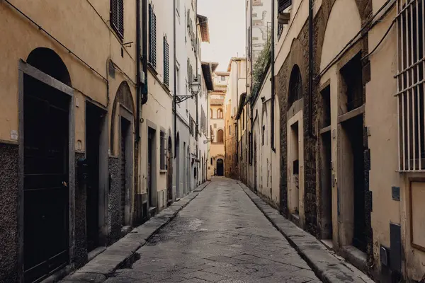 Floransa 'nın tarihi binalarla çevrili dar bir patikanın huzurlu manzarası, yumuşak gün ışığında zamansız cazibe ve sükunet öneriyor, mimari detayları gözler önüne seriyor ve keşif için davetkar bir ortam yaratıyor. Kimse yok..