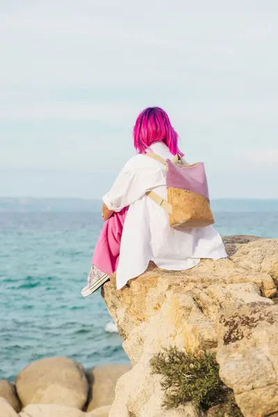 Yunanistan 'ın Karydi Sahili' nde Pembe Saçlı ve Sırt çantalı Kız Kaya Üstünde Oturuyor Yaz Tatili Sahnesi