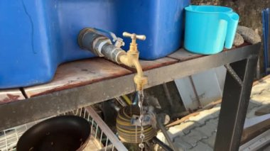 Türkiye 'nin kırsal kesimindeki bir su tankına bağlı bir musluktan akan su