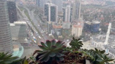 İstanbul, Türkiye - Mart 2023: Gökdelenleri ve trafiği olan Levent finans bölgesi, yağmurlu bir günde pencereye konan yağmur damlalarıyla dolu bir pencerenin ardında görülüyor. Seçici odak ve bulanıklık