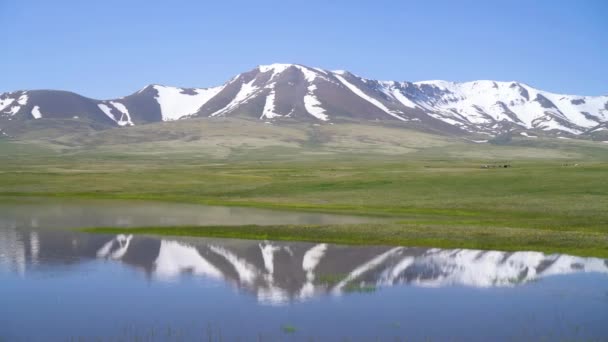 キルギスのソンクル湖高原によって反射湖と広大な山々とキルギスの自然緑の風景 キルギスは中央アジアに位置する内陸国です — ストック動画