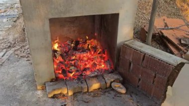 Şöminede yanan bir odun, yanan bir odun kütüğü. Yanan odundan dolayı kızgın közler ve kül.