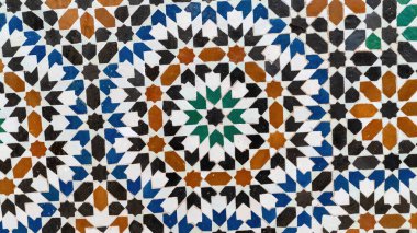 İslami tasarımı olan geleneksel Fas fayansları, geometrik şekiller ve çiçek motifleri gibi el yapımı renkli desenler. Bu fayanslar evlerde ve camilerde duvarları ve zemini süslemek için kullanılır..