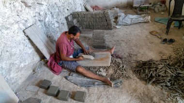 Fes, Fas - 10 Eylül 2022 Faslı zanaatkar fayansları tam kare şeklinde kesiyor. Bu fayanslar çimento, kum ve pigment karışımı bir kalıpla oluşturulmuştur..