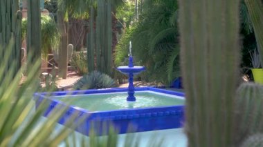 Marakeş, Fas - 12 Eylül 2022: Yves Saint Laurent 'in Majorelle Bahçesi içindeki mavi çeşme, Casa Oasis, Marakeş' te Yves Saint Laurent tarafından tasarlanmış bir botanik bahçesi.