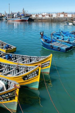 Essaouira, Fas - 17 Eylül 2022: Geleneksel balıkçı tekneleri Essaouira limanına yanaştı. Balıkçı tekneleri limana yanaşıyor, günün avını getiriyorlar, martılar da tepemizde daireler çiziyor.
