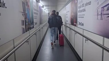 İstanbul, Türkiye - 13 Kasım 2023: İstanbul Havaalanı 'ndaki Türk Hava Yolları uçağına binmek üzere koridorda yürüyen yolcular