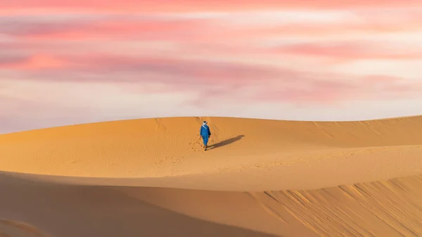 stock image Sahara Desert, Morocco - 13 September 2022: Unidentified Berber man in his traditional clothing, a long robe on sand dunes in Sahara Desert, Morocco