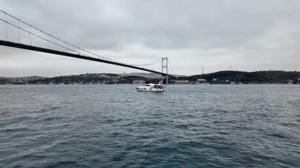 イスタンブール トルコ 2023年12月7日 ボスポラス海峡の私用ヨットが 7月15日の殉教者橋の下を通過しようとしています — ストック動画