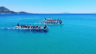 Marmaris, Türkiye - 12 Temmuz 2023: Akdeniz 'in turkuaz renginde yarışan ejderha tekneleriyle takımlar uzun ve dar botlarla kürek çekiyorlar