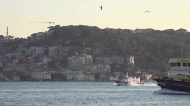 İstanbul, Türkiye - 12 Ekim 2023: İstanbul 'un Avrupa ve Asya taraflarını ayıran bir balıkçı teknesi İstanbul Boğazı boyunca sorunsuzca süzülüyor