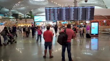 İstanbul, Türkiye - 12 Ekim 2023: Yolcular, İstanbul Havalimanı 'ndaki uçuş bilgilerini ve uçuş durumlarını görmek için uçuş bilgilerimizi kontrol ediyorlar