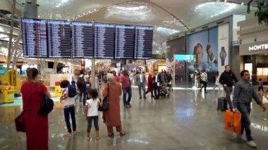 İstanbul, Türkiye - 12 Ekim 2023: Yolcular, İstanbul Havalimanı 'ndaki uçuş bilgilerini ve uçuş durumlarını görmek için uçuş bilgilerimizi kontrol ediyorlar
