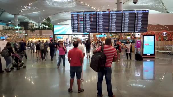 イスタンブール トルコ 10月2023 乗客は 彼らのゲート番号とイスタンブール空港でのフライトの状態を確認するために私たちのフライト情報のタイムテーブルをチェックしています — ストック動画