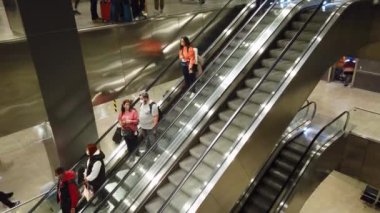 İstanbul, Türkiye - 12 Kasım 2023: İnsanlar kalkış kapılarına yürüyen merdivenlerle gidiyorlar. Sabihe Gokcen havaalanı içinde insan trafiği.