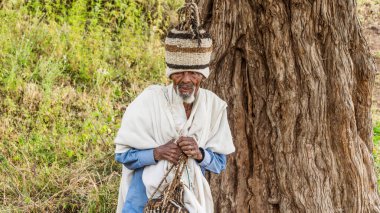 Lalibela, Etiyopya - 24 Ekim 2023: On bir ortaçağ kaya yontulmuş kilisesiyle ünlü Lalibela 'yı ziyaret eden bir hacı, 12. ve 13. yüzyıllarda katı kayalardan oyulmuş..